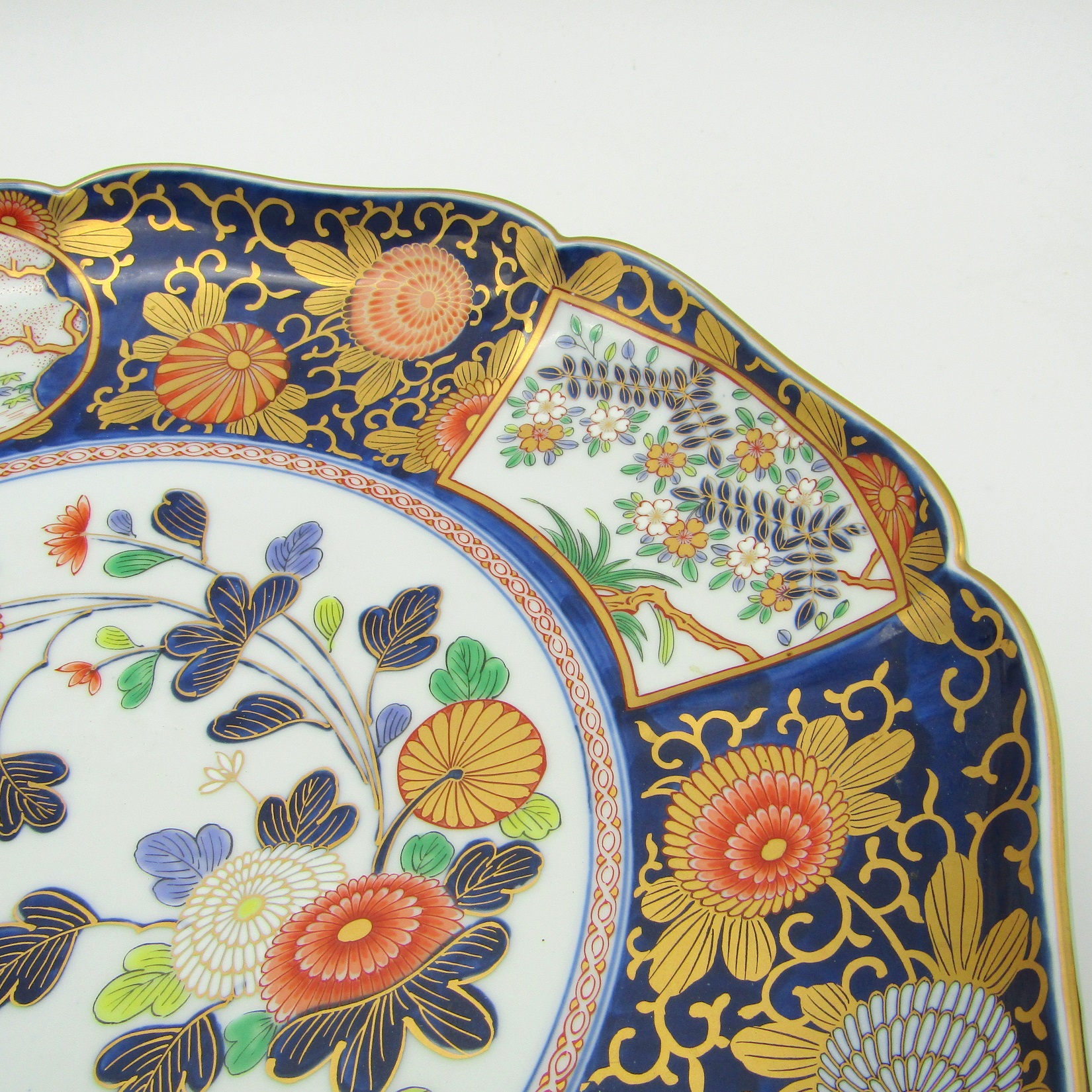 Japon. Plat en porcelaine à décor polychrome de fleurs et paysages, XXe