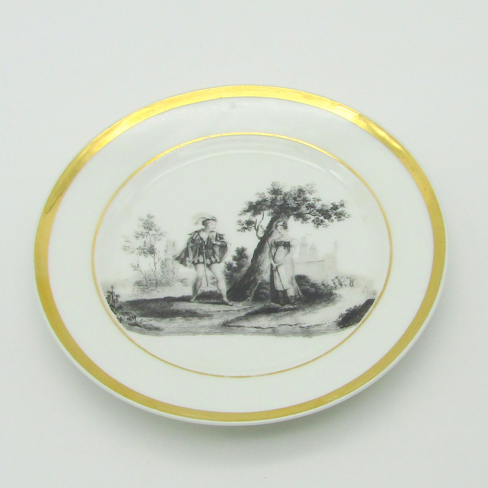 Paris. Assiette en porcelaine à décor d\'une scène galante en grisaille, XIXe