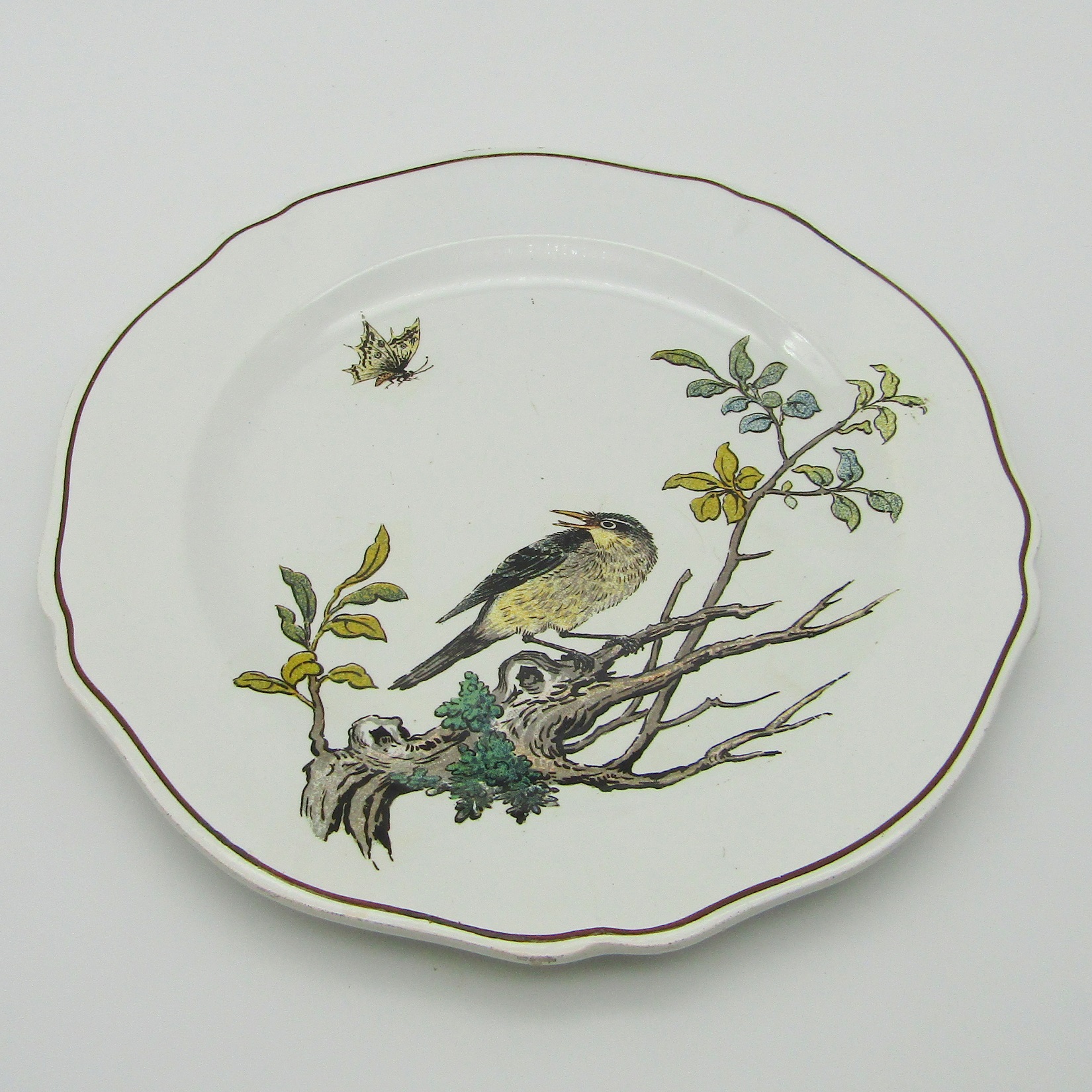 Gien. Assiette en faïence décor d\'un oiseau et d\'un papillon, XIXe siècle
