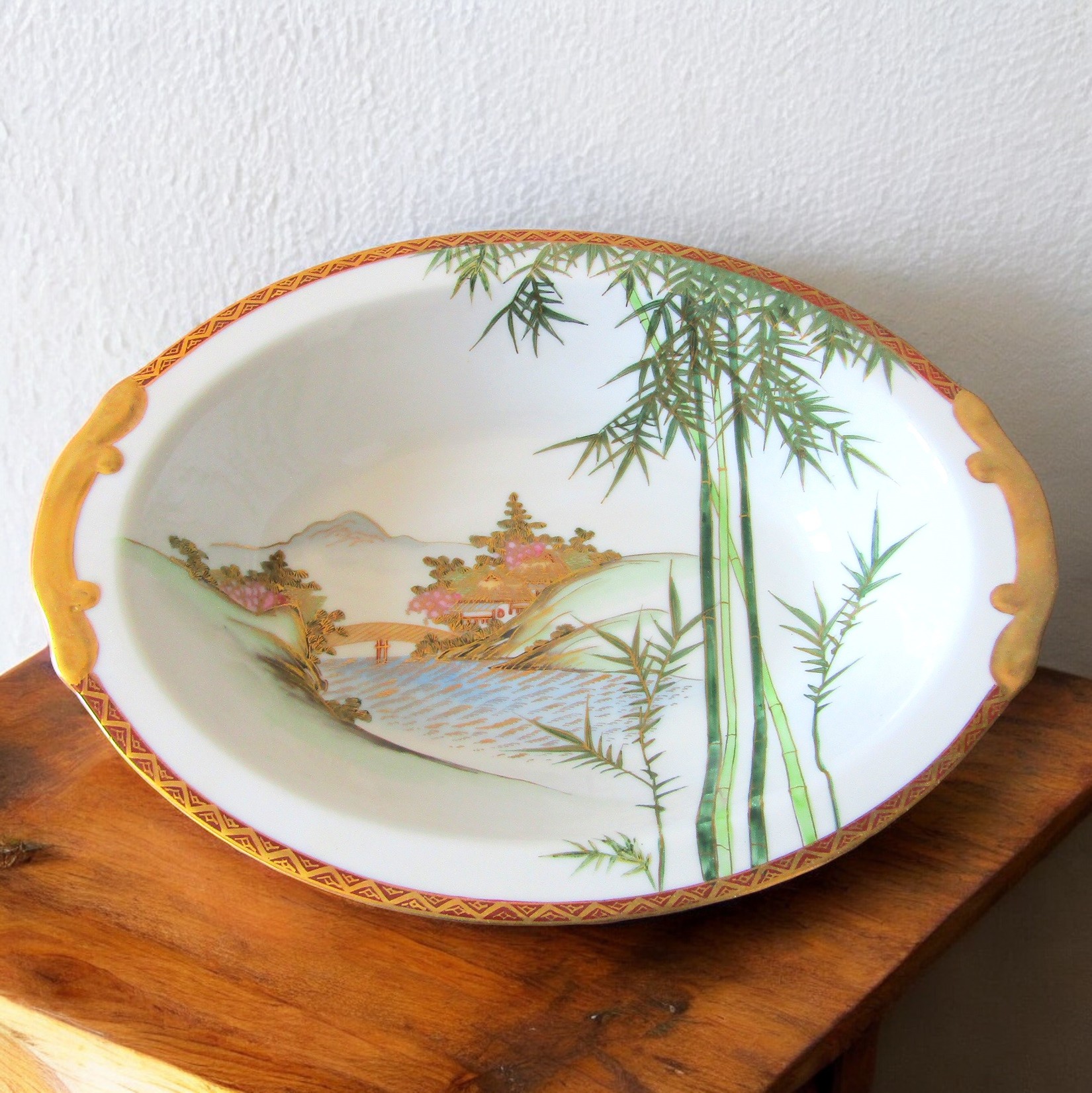 Japon. Kutani. Plat creux ovale porcelaine à décor polychrome or paysages, XXe