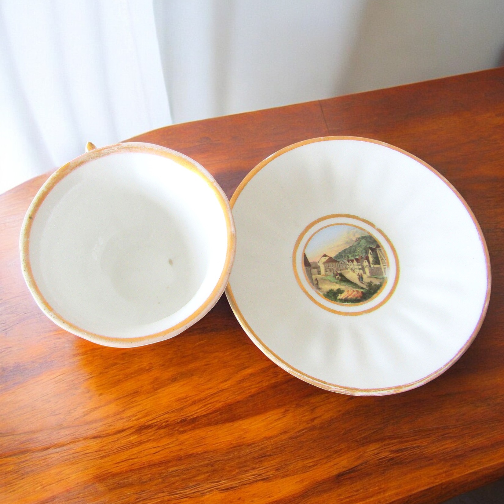 KPM Berlin. Tasse en porcelaine à décor polychrome de paysages, début XXe siècle