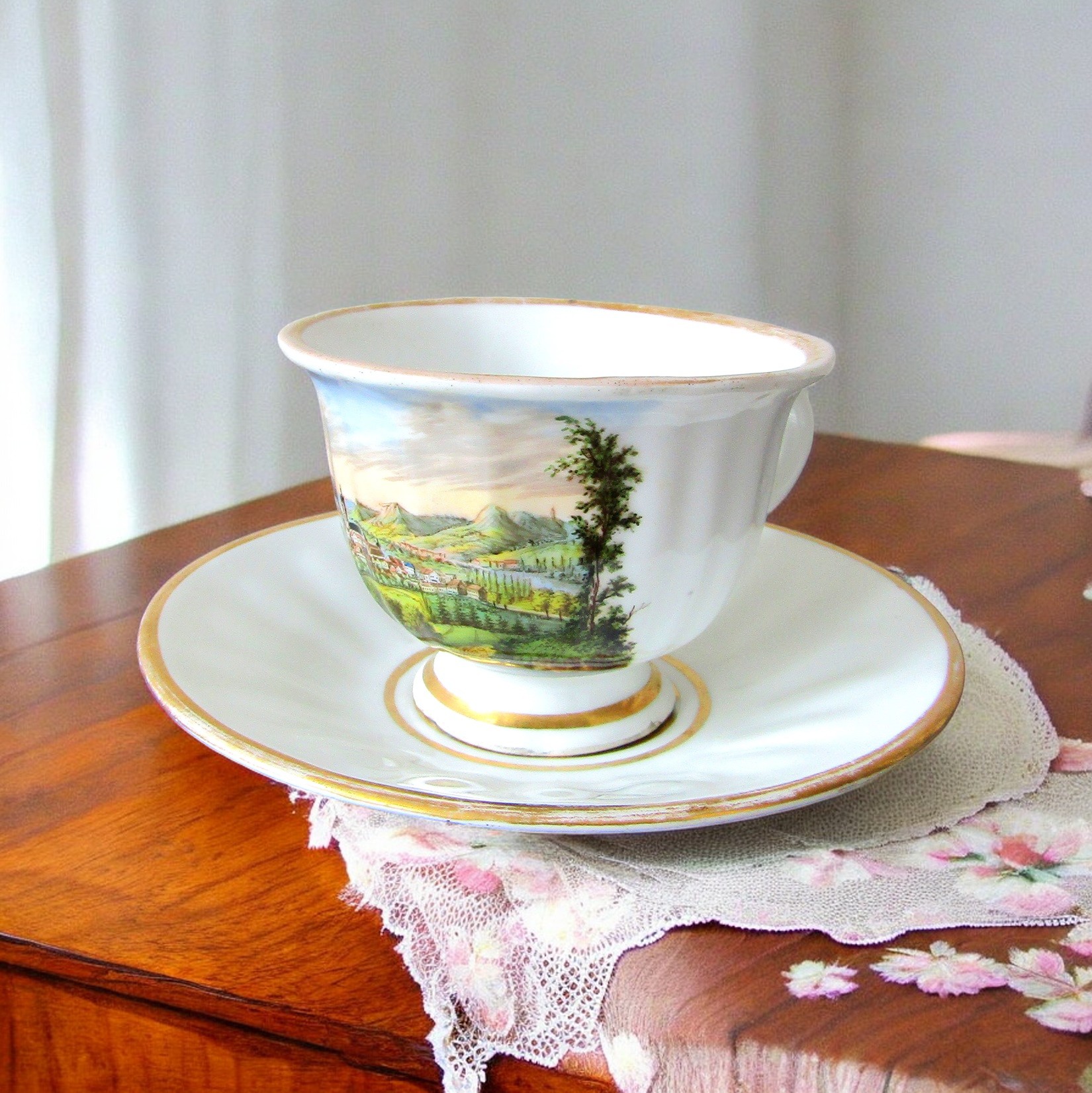 KPM Berlin. Tasse en porcelaine à décor polychrome de paysages, début XXe siècle