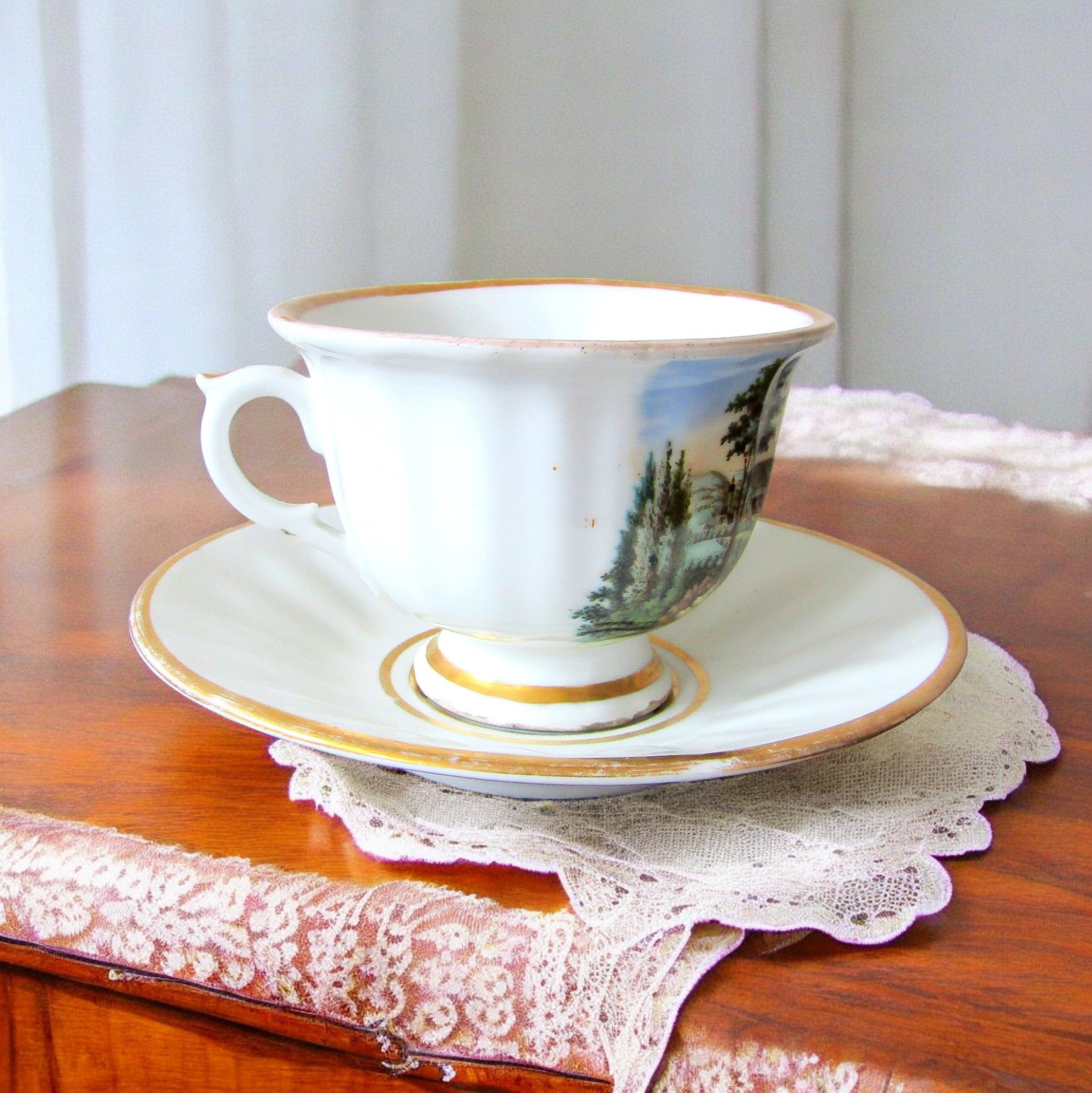 KPM Berlin. Tasse en porcelaine à décor polychrome de paysages, début XXe siècle