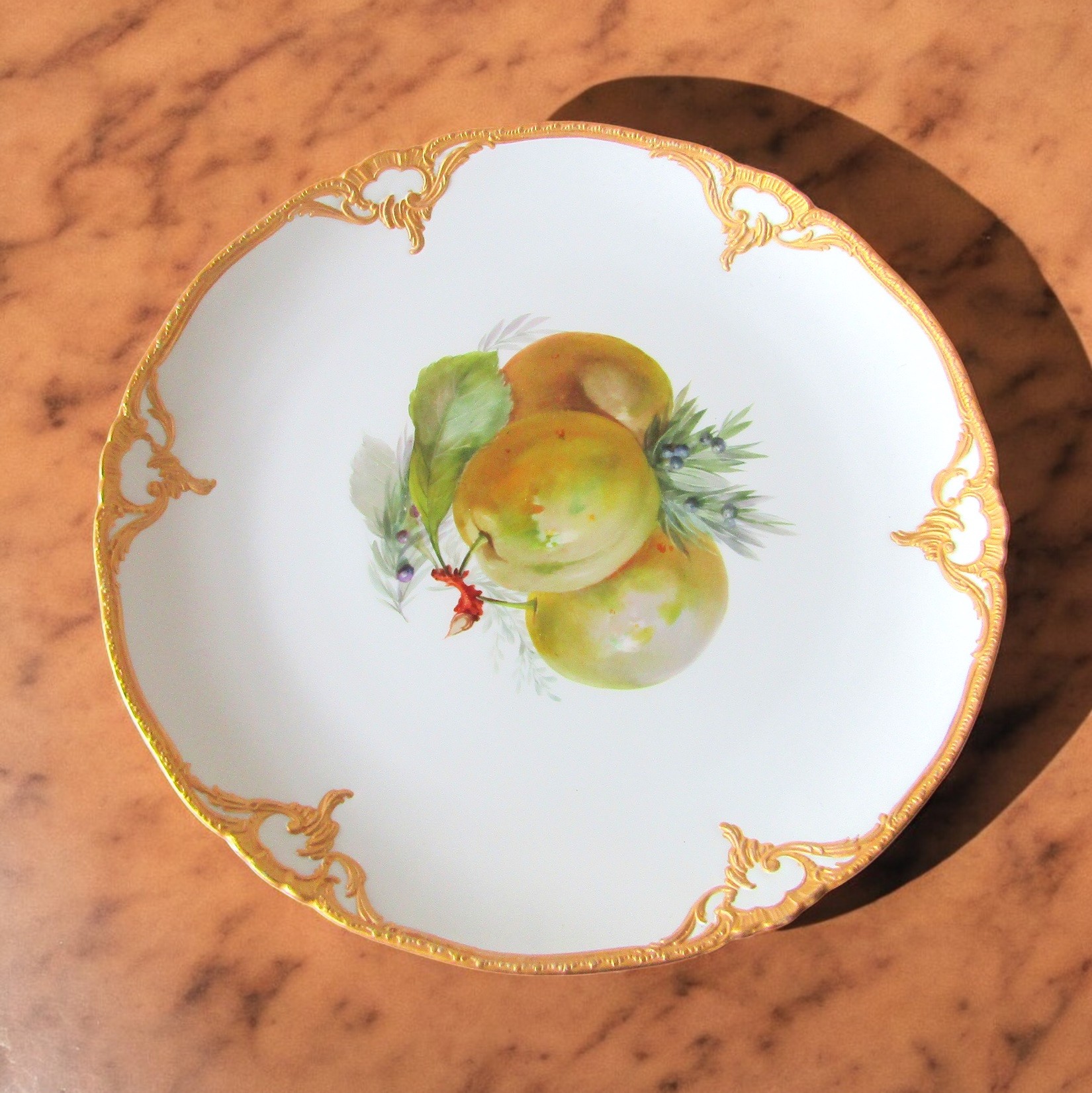 KPM Berlin. Assiette en porcelaine décor polychrome de pommes, début XXe siècle