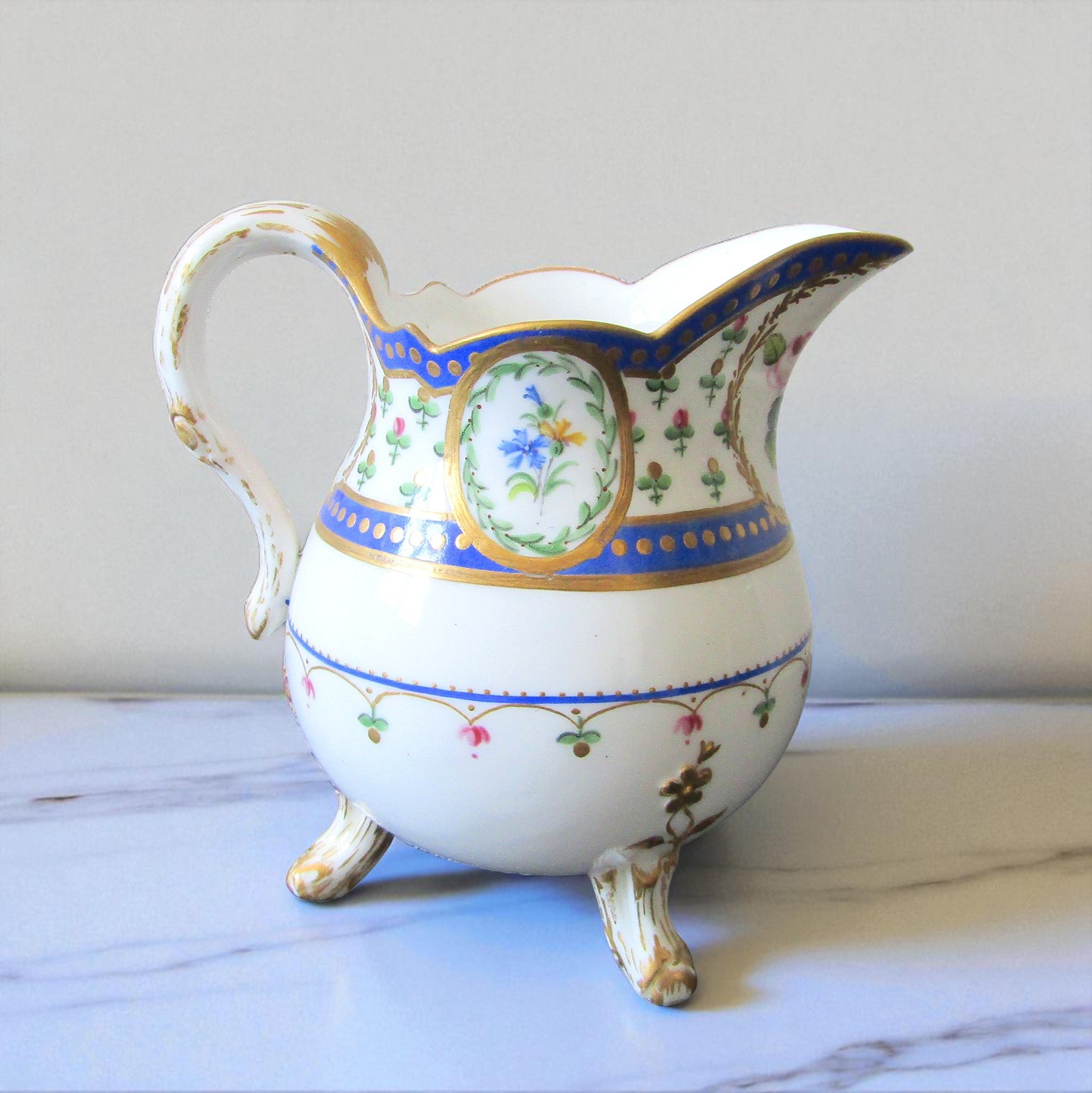Sèvres. Pot à lait tripode en porcelaine à décor de fleurs dans des réserves, XVIIIe siècle