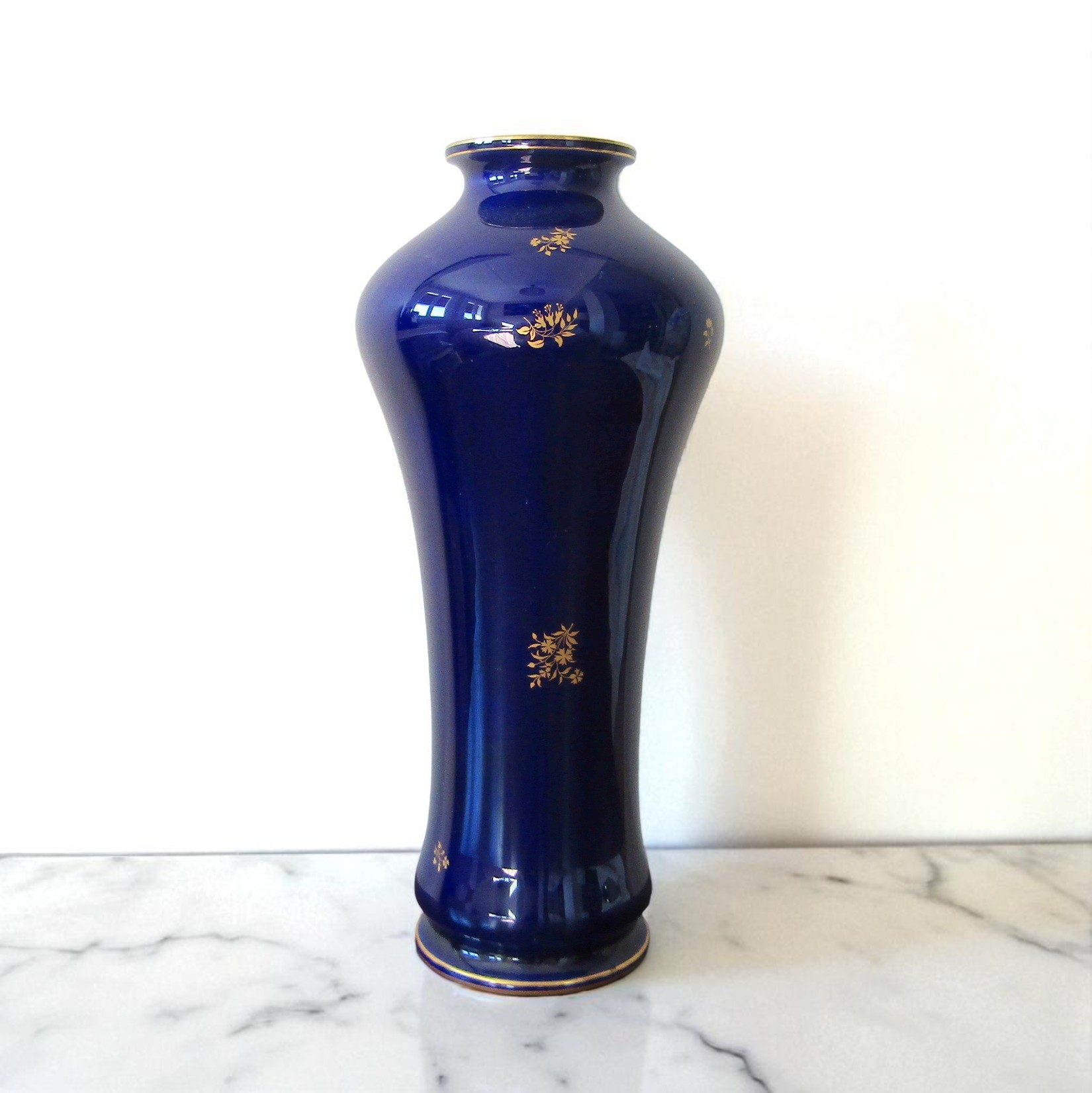 Sèvres. Vase en porcelaine à fond bleu décor de brins fleuris or, fin XIXe