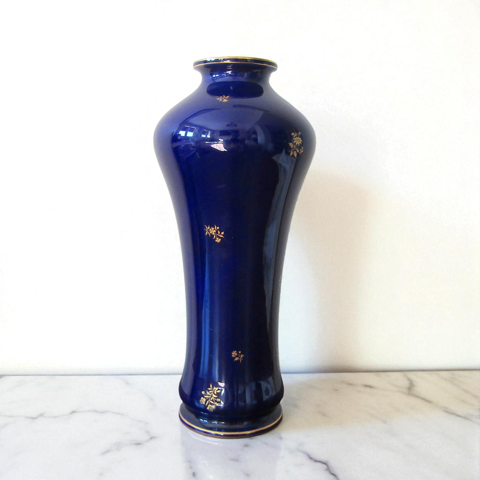 Sèvres. Vase en porcelaine à fond bleu décor de brins fleuris or, fin XIXe