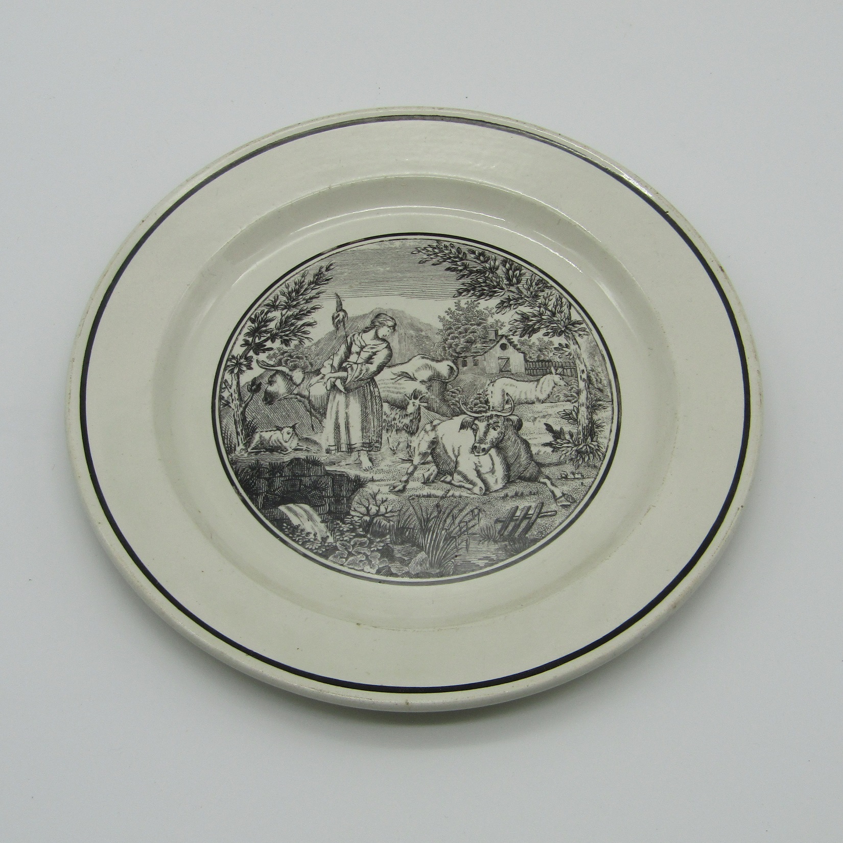 Sarreguemines. Assiette en faïence décor grisaille d\'une bergère et son troupeau, XIXe siècle