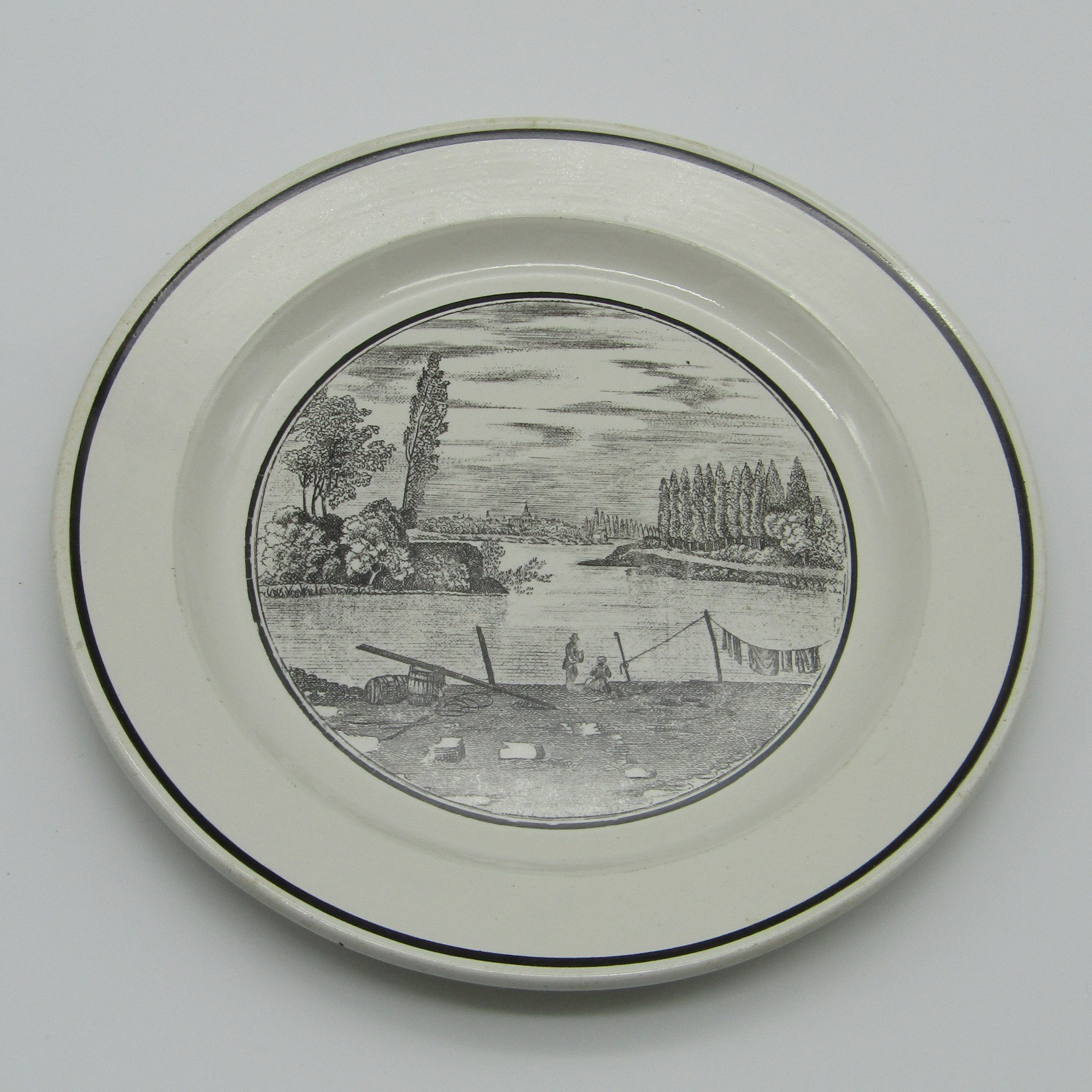 Sarreguemines. Assiette en faïence à décor de personnages au bord d'une rivière, XIXe siècle