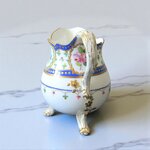 Sèvres. Pot à lait tripode en porcelaine à décor de fleurs dans des réserves, XVIIIe siècle