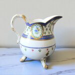 Sèvres. Pot à lait tripode en porcelaine à décor de fleurs dans des réserves, XVIIIe siècle