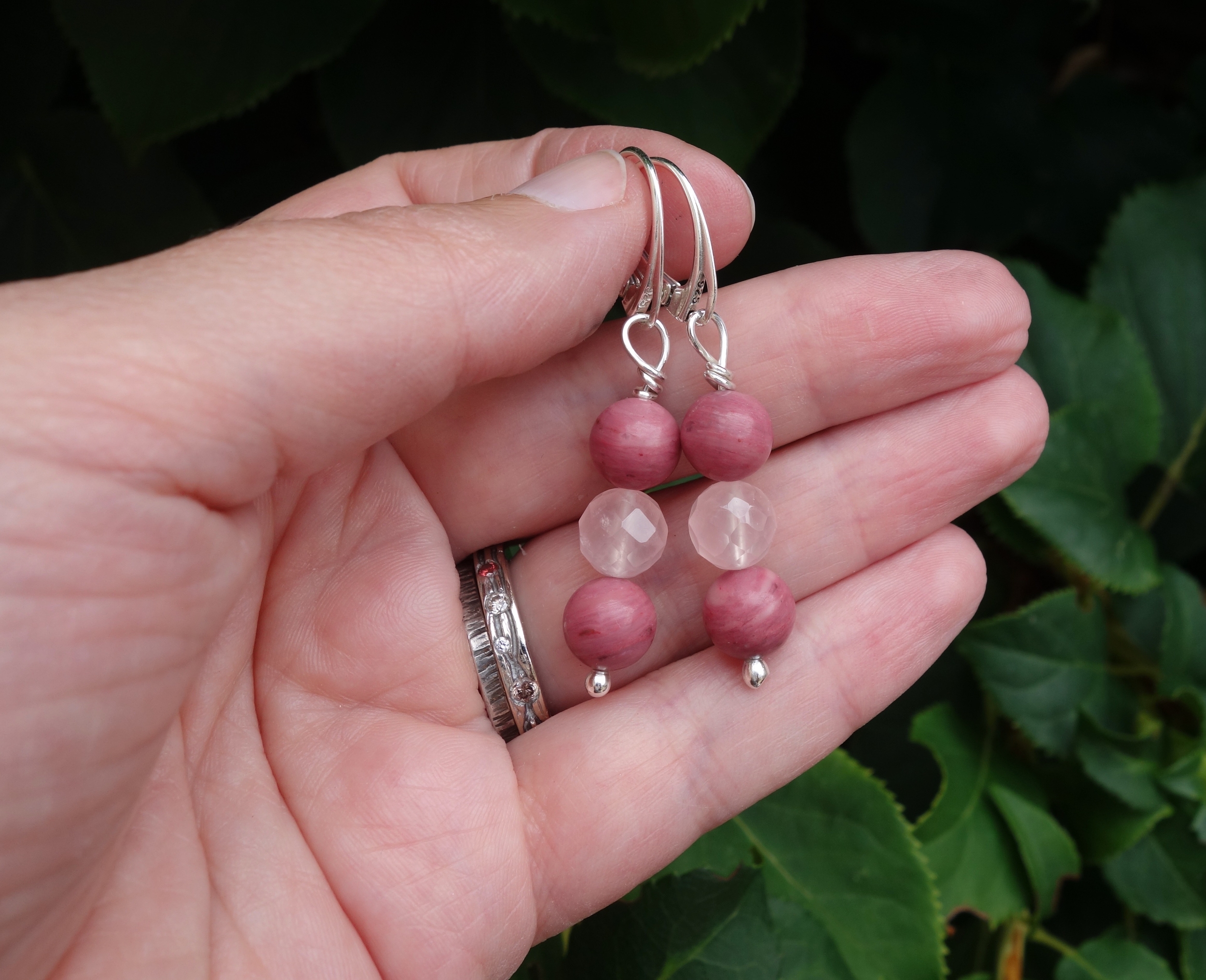 Boucles doreilles &quot;Simplissimes&quot; rhodonite et quartz rose. Photo sur la main, en extérieur à la lumière du jour