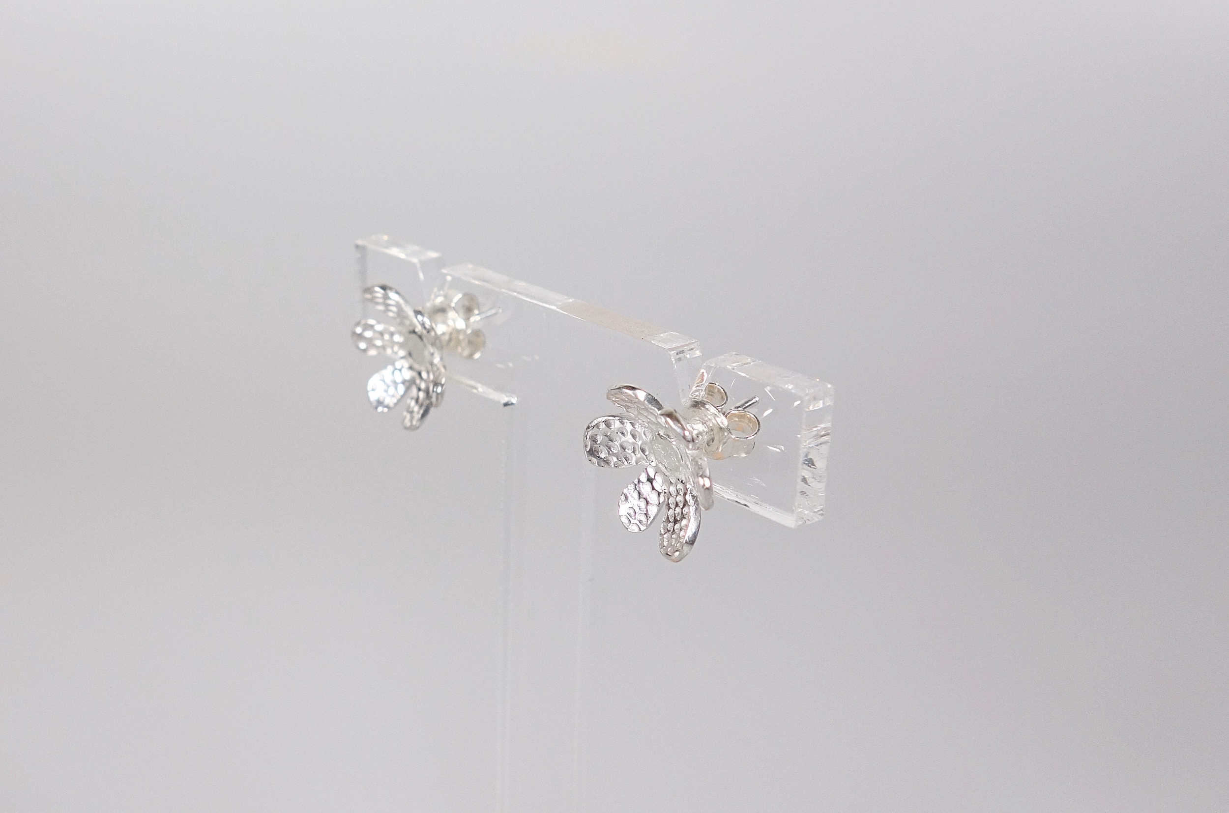 Boucles doreilles fleur Pointillisme en argent massif ciselé, sur fond blanc, vue de profil