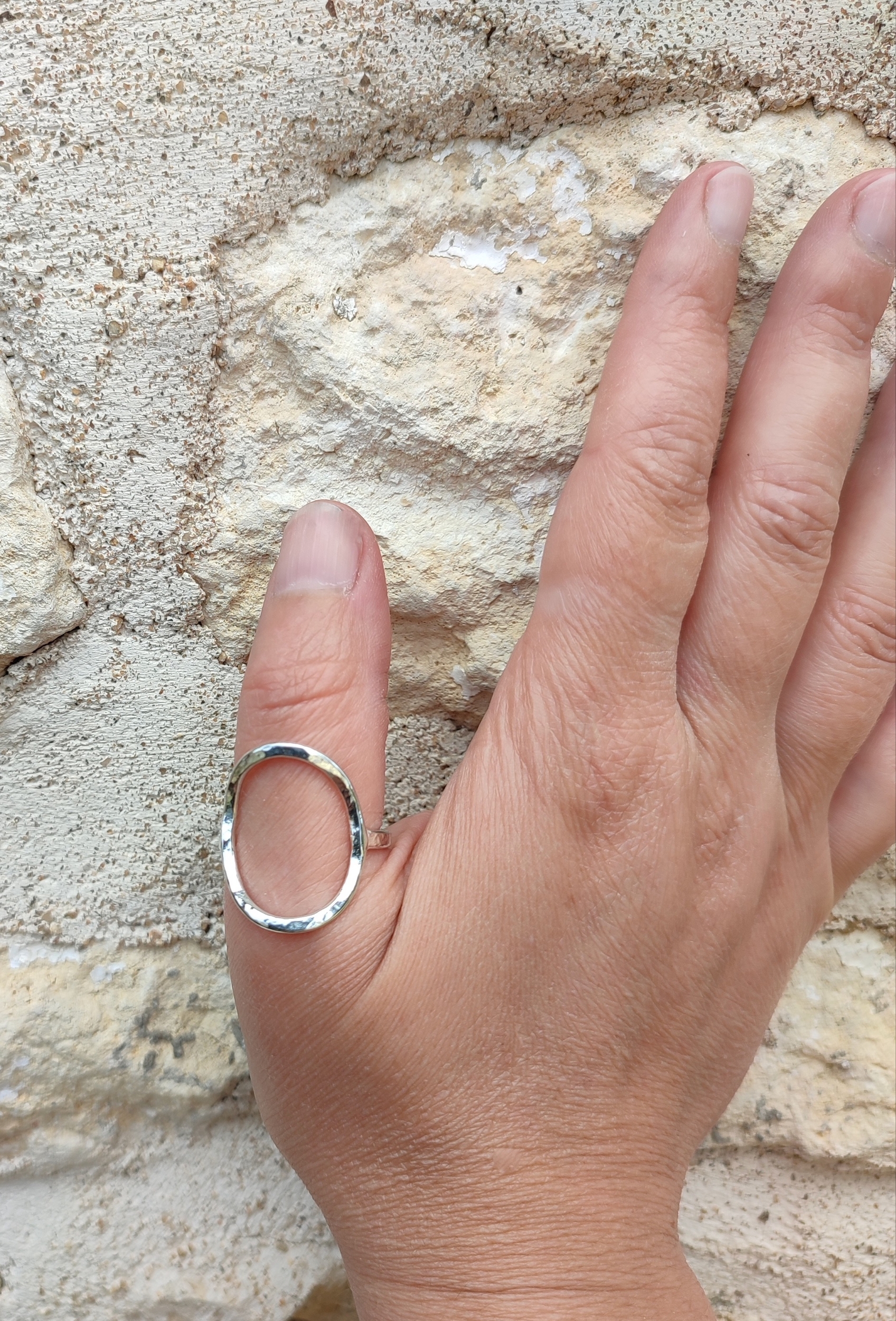 Bague épurée et martelée ovale en argent vue de face portée