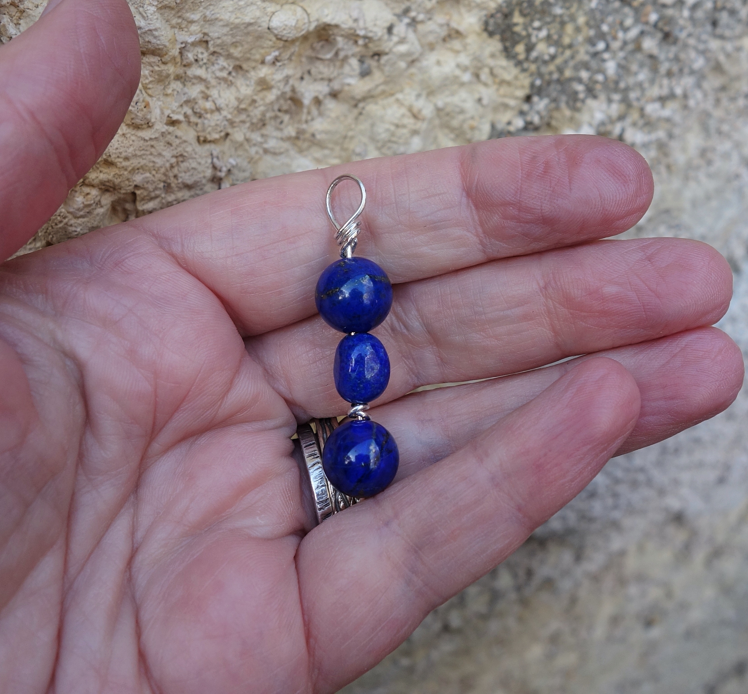 Pendentif &quot;simplissimes&quot; en argent et lapis lazuli sur la main à la lumière naturelle