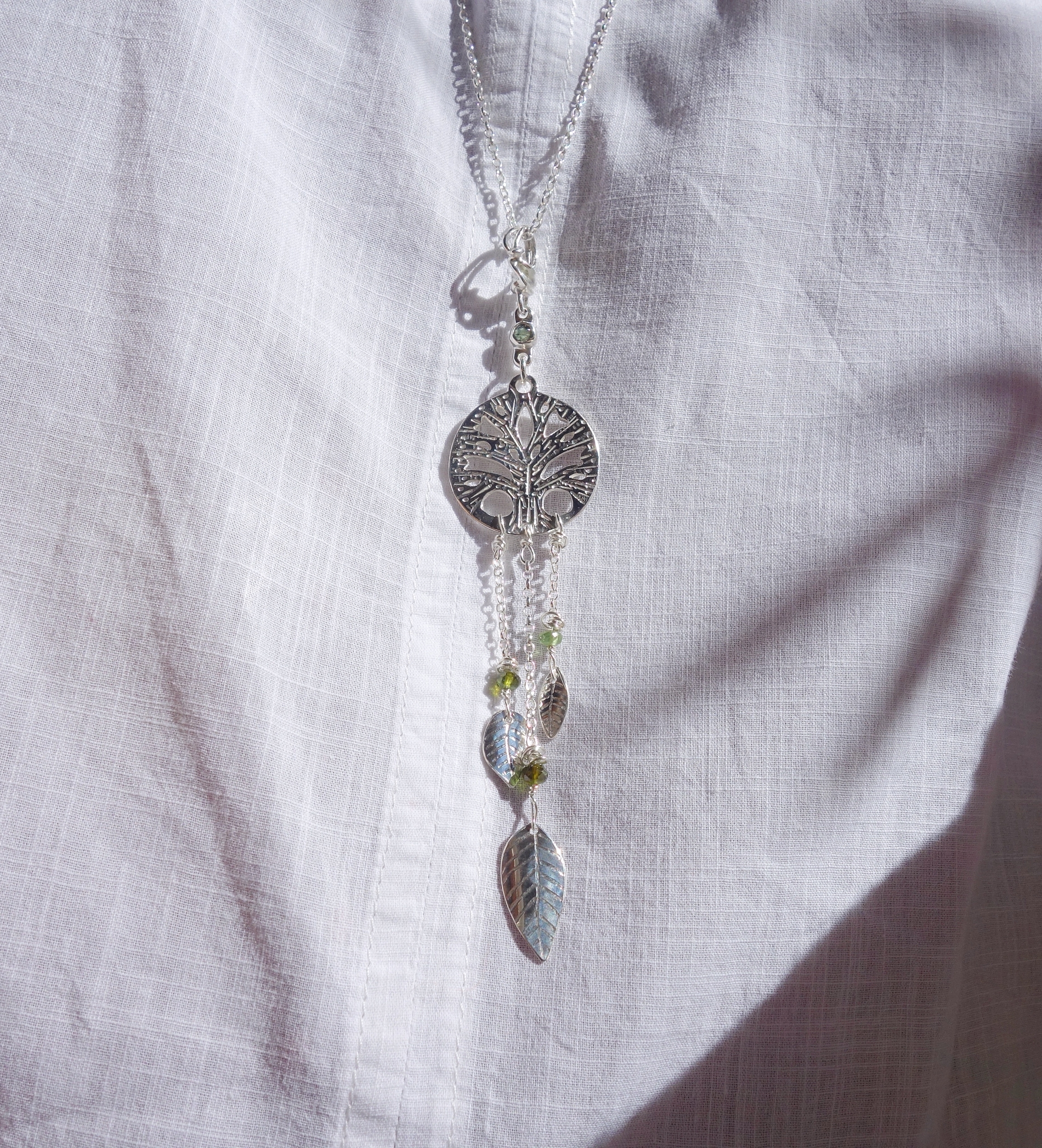 Pendentif &quot;arbre de vie&quot; avec pendants en argent massif et tourmaline verte. Talisman., vue porté à la lumière du jour.