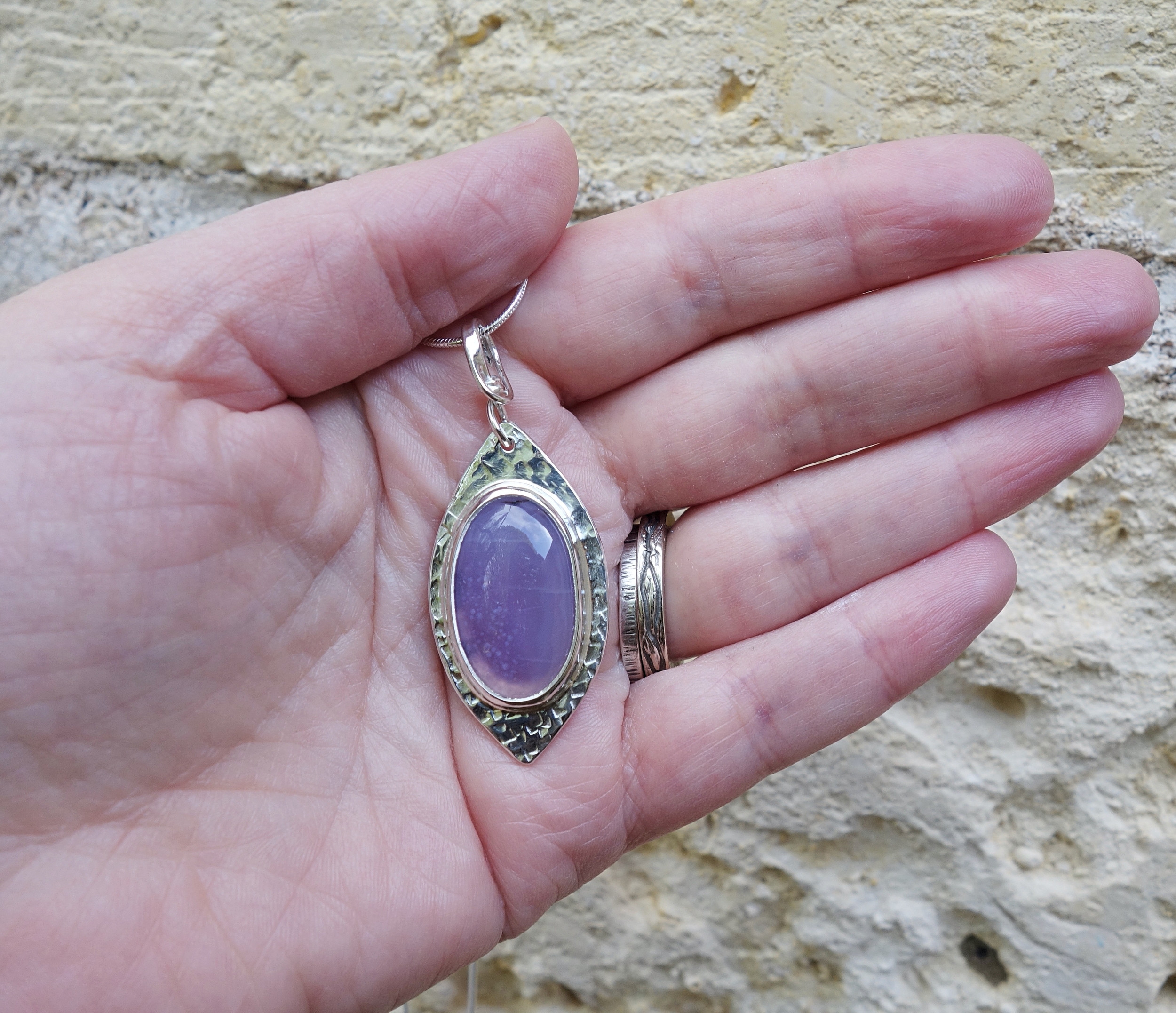 Féérie. Pendentif argent massif et agate. Bijou nature. Violet. Photo sur la main en extérieur. Pétale dargent.