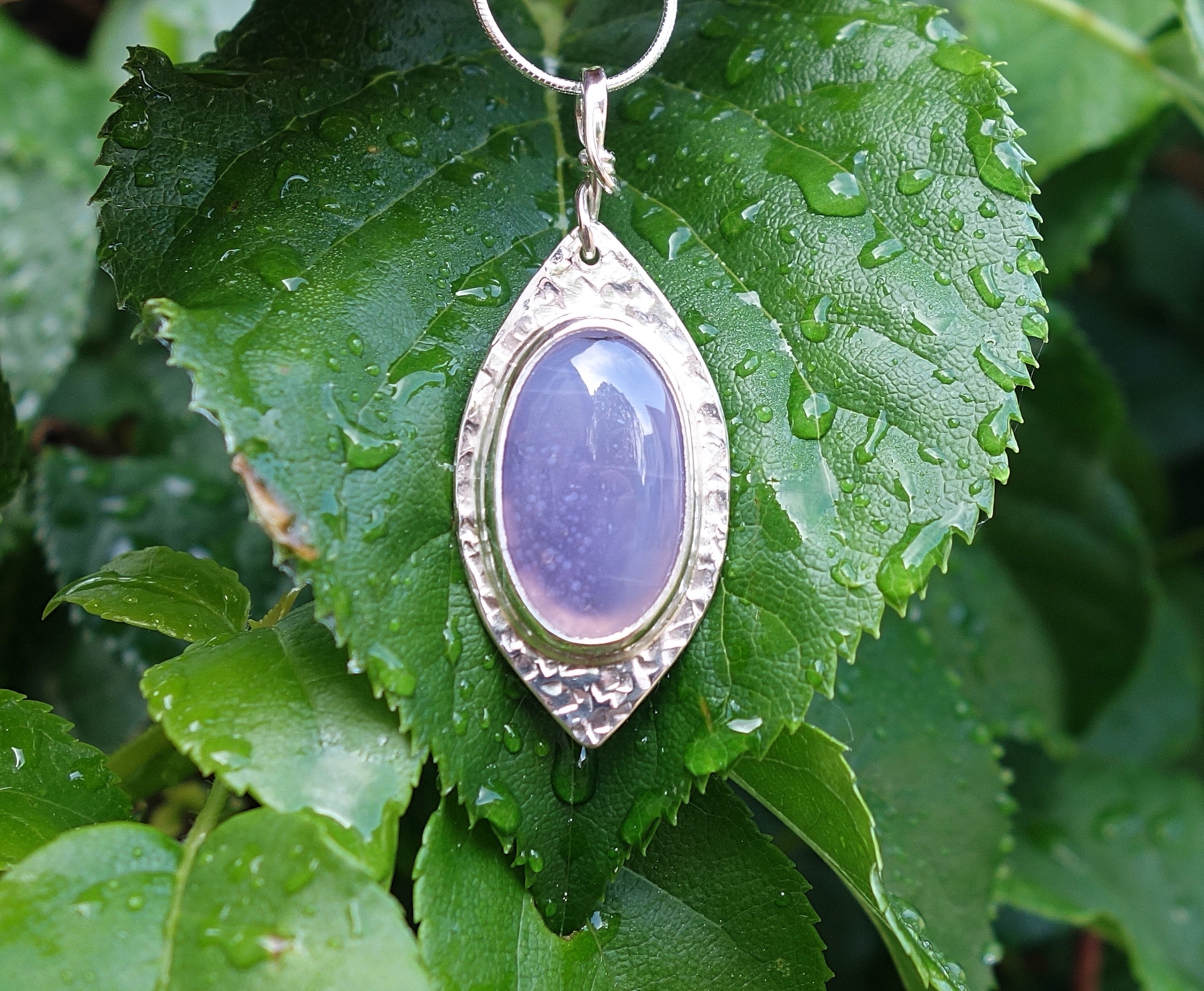 Féérie. Pendentif argent massif et agate. Bijou nature. Violet. Photo en extérieur sur feuilles dhortensia. Pétale dargent.