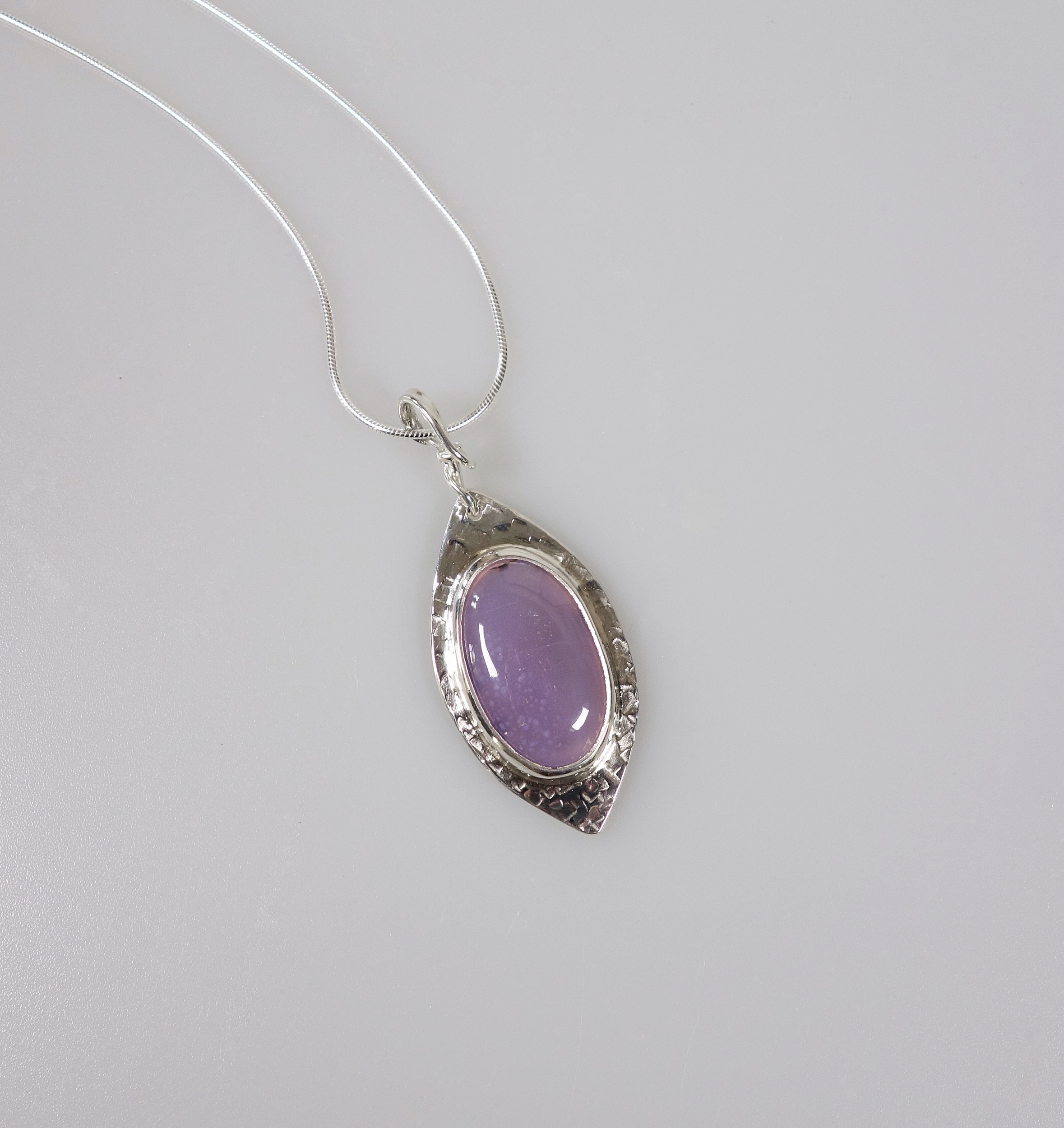 Féérie. Pendentif argent massif et agate. Bijou nature. Violet. Photo de face sur fond blanc. Pétale dargent.