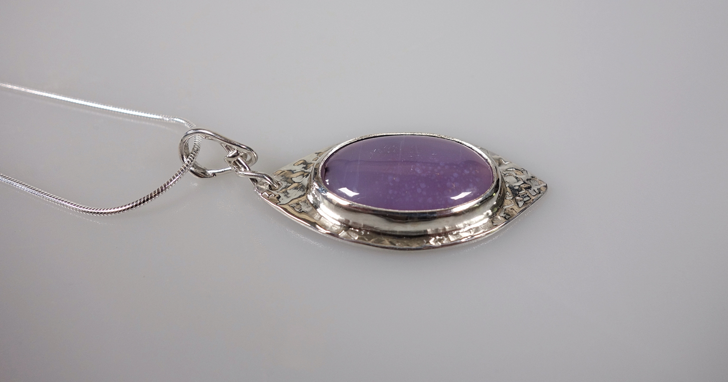 Féérie. Pendentif argent massif et agate. Bijou nature. Violet. Photo de profil sur fond blanc. Pétale dargent.