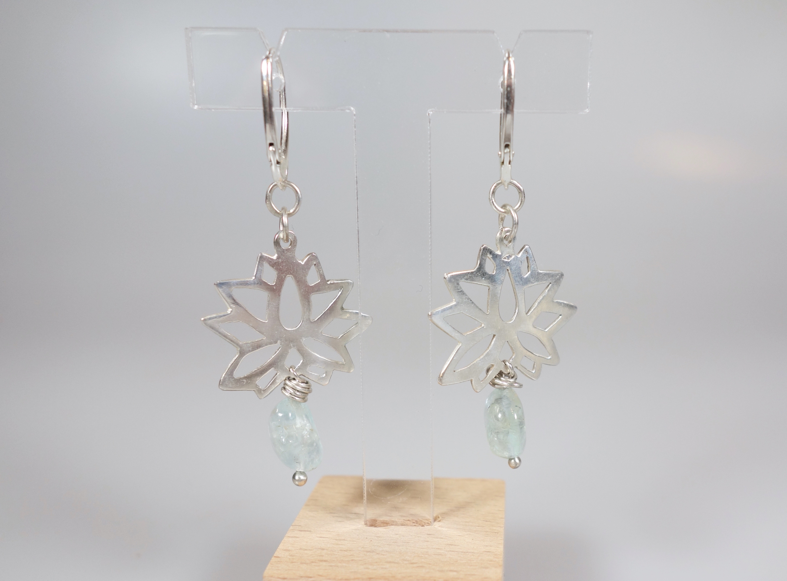Lotus sacré. Boucles doreilles. Bijou nature. Argent et béryl. Bleu ciel. Vue de dos sur fond blanc.Pétale dargent. .
