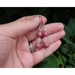 Boucles doreilles Simplissimes rhodonite et quartz rose. Photo sur la main, en extérieur à la lumière du jour