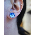 Paire de puces d'oreilles "Floral" avec émail bleu outremer et blanc, vue portée, à la lumière du jour