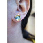 Paire de puces d'oreilles "Floral" avec émail jaune, argent et blanc, vue portée, à la lumière du jour