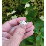 Commande personnalisée bague fleurs en argent massif ciselé, photo en extérieur entre les doigts