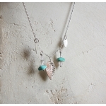 Collier ethnique en argent massif avec feuilles et perles de turquoise, quartz rose et cristal de roche., vue contre un mur de pierres. Création Pétale dargent.