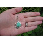Pendentif en argent massif et turquoise vu sur la main en extérieur. Pétale dargent