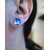 Paire de puces d'oreilles "Floral" avec émail bleu outremer et blanc, vue portée, à la lumière du jour