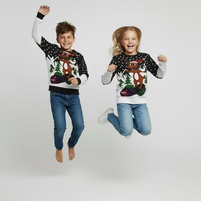 Jongen en meisje in kinderkersttrui Rudolph op de sneeuwscooter