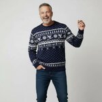 Man in marineblauwe kersttrui met skiers, kerstbomen en tekst Après-ski