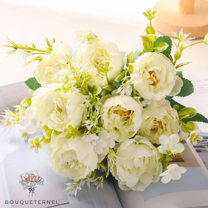 Composition de fleurs pour bouquet nuptial, comportant des roses blanches épanouies et des accents de fleurs blanches plus petites