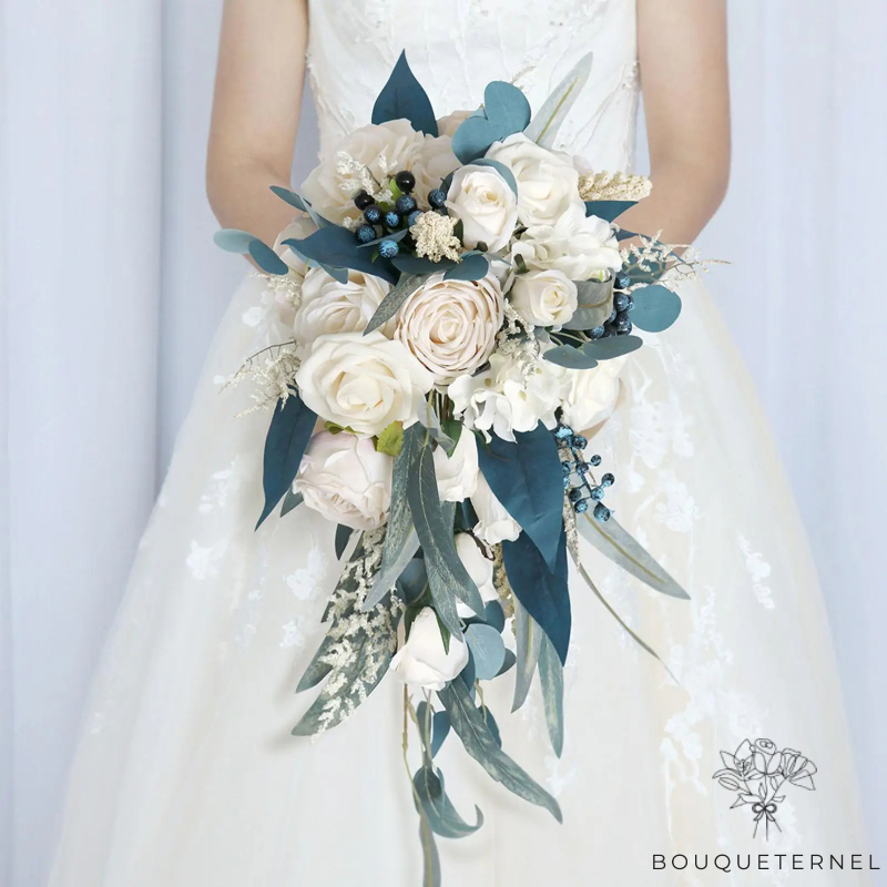 Bouquet nuptial blanc et bleu avec des fleurs de roses blanches, des accents de baies bleues et des feuilles d'eucalyptus, disposées de manière tombante
