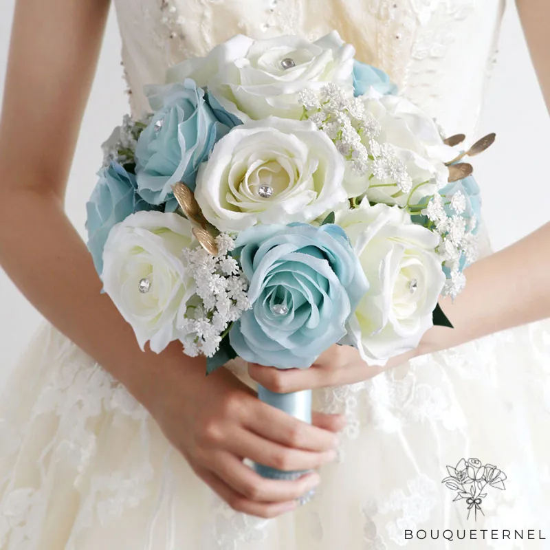 Composition nuptiale aux roses bleues et blanches, parfaitement arrangée avec des fleurs d'accent blanc et des feuilles vertes, pour un look classique