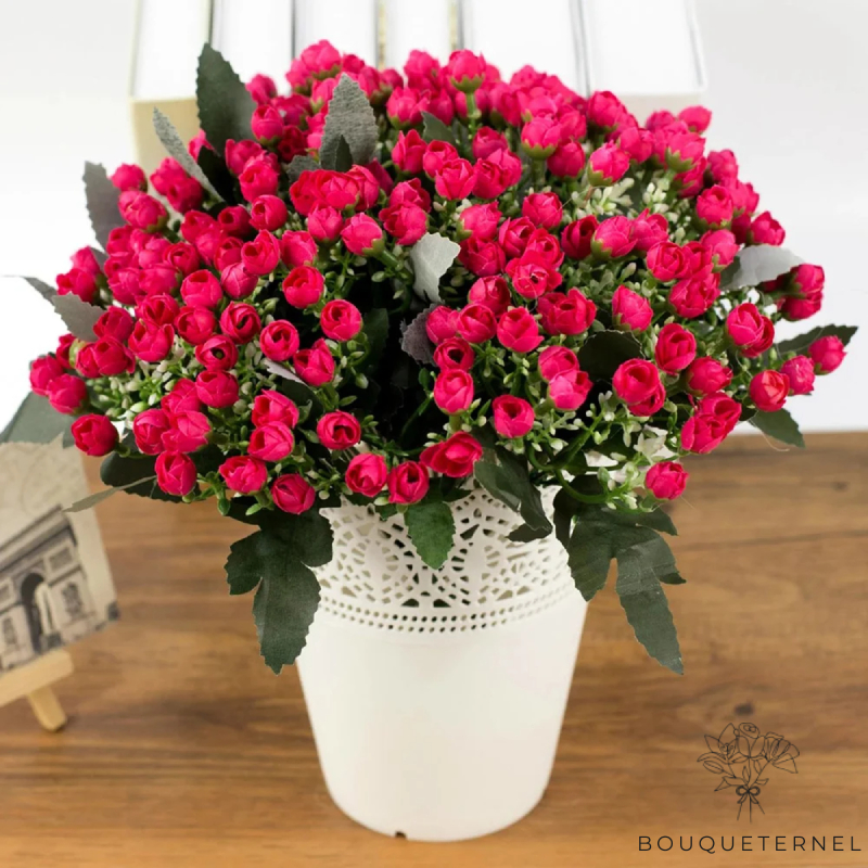 Fleurs artificielles de cimetière, bouquet de pivoines rouges vives, abondamment disposées dans un vase blanc décoratif