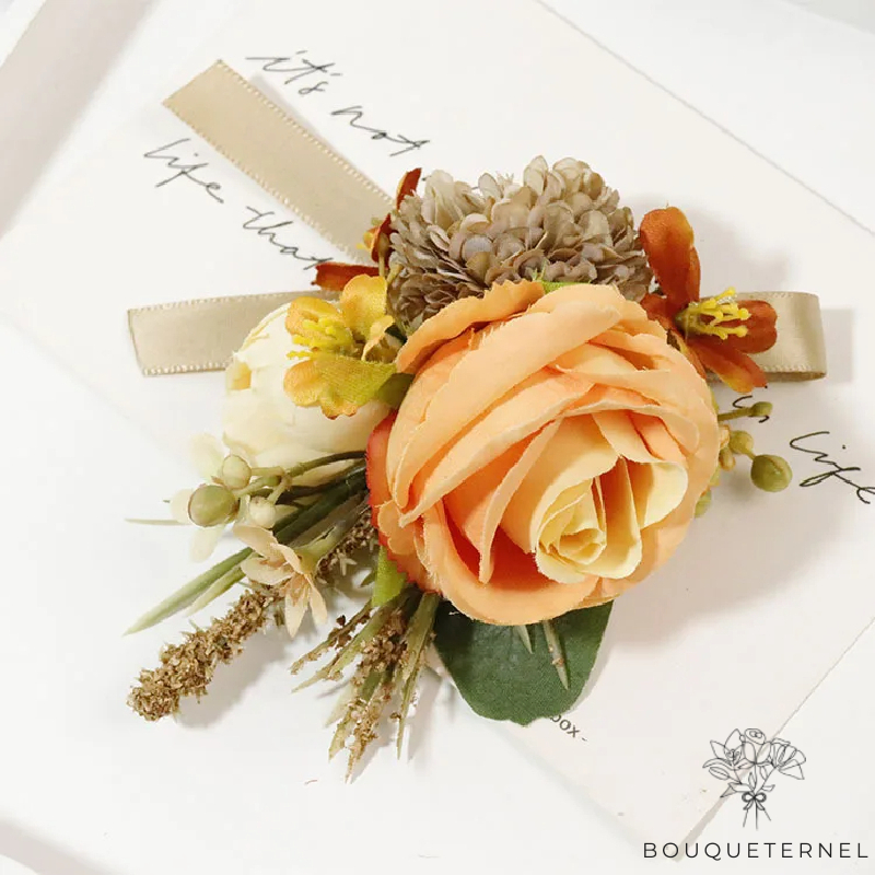 Boutonnière pour mariage, style champêtre, avec rose pêche, fleur blanche, et touches de vert et d'orange