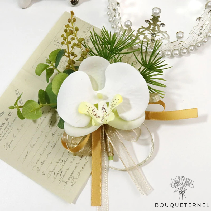 Boutonnière avec orchidée blanche et rubans dorés, parfaite pour un costume de marié