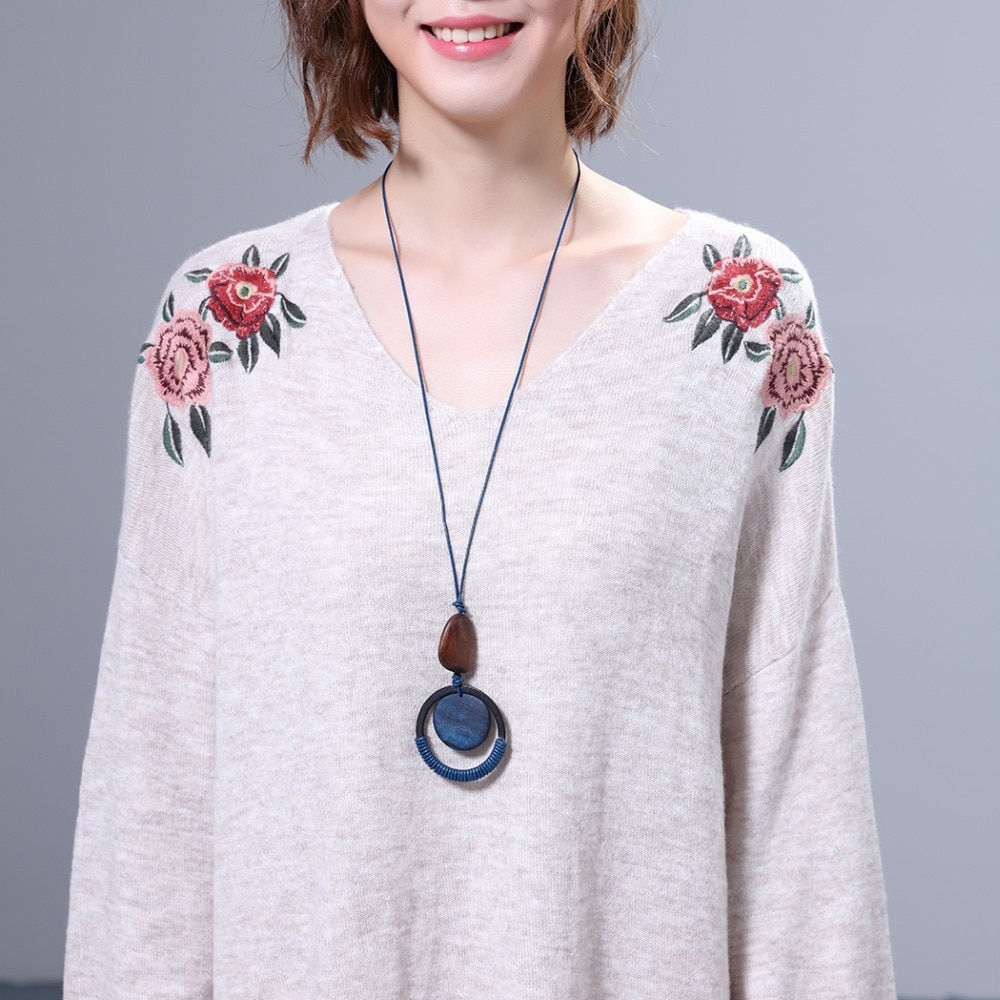 Pfemme avec collier grand pendentif en bois bleu