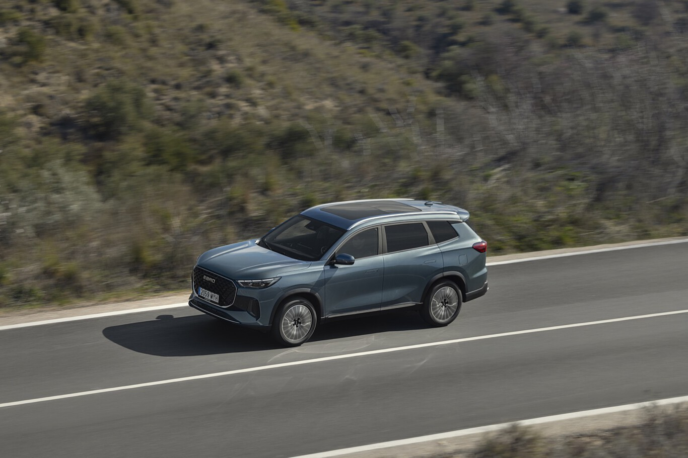 SUV familial bleu roulant sur une route de montagne à vive allure