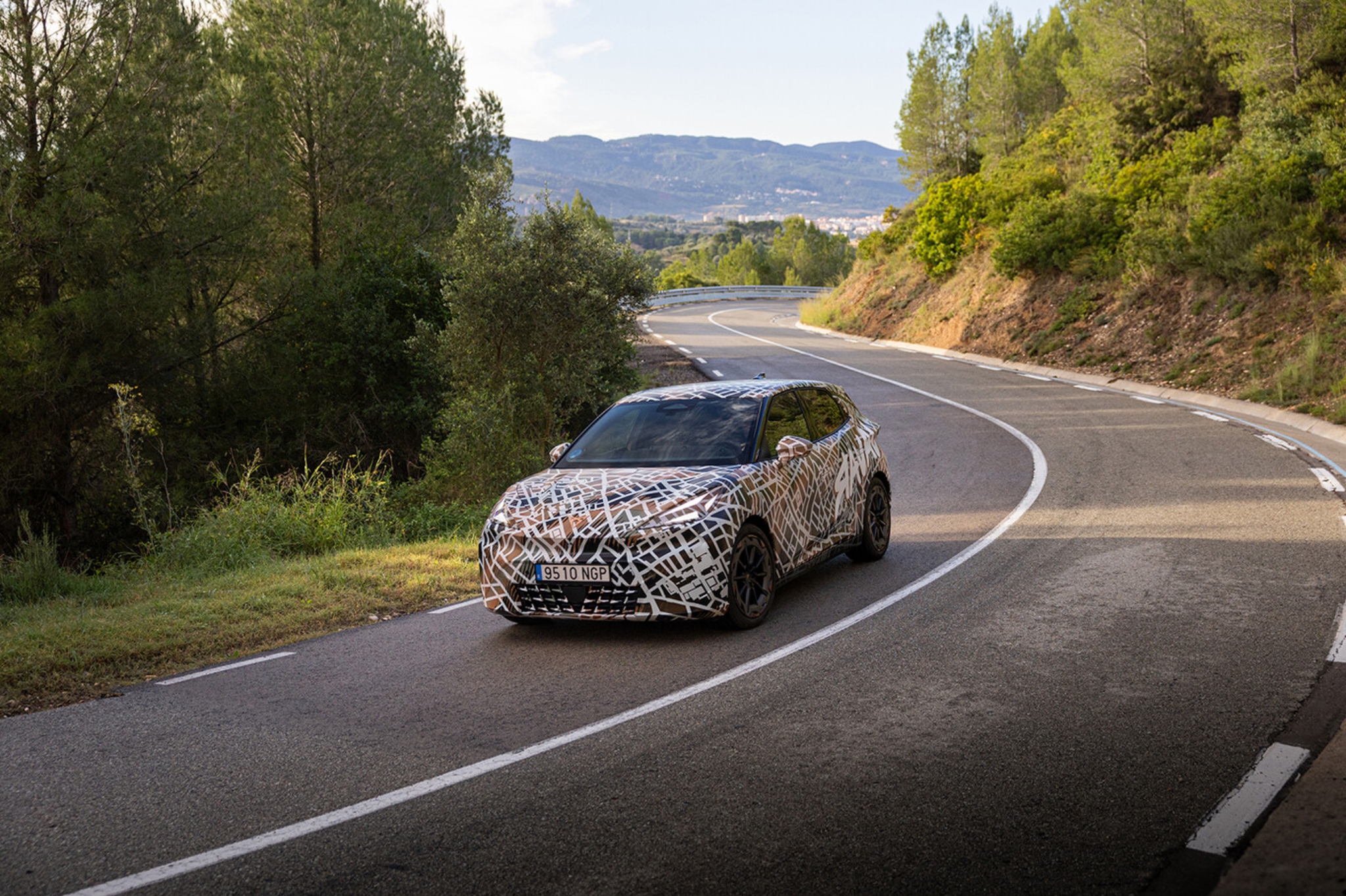 Cupra Raval prototype camouflé en virage sur route de montagne