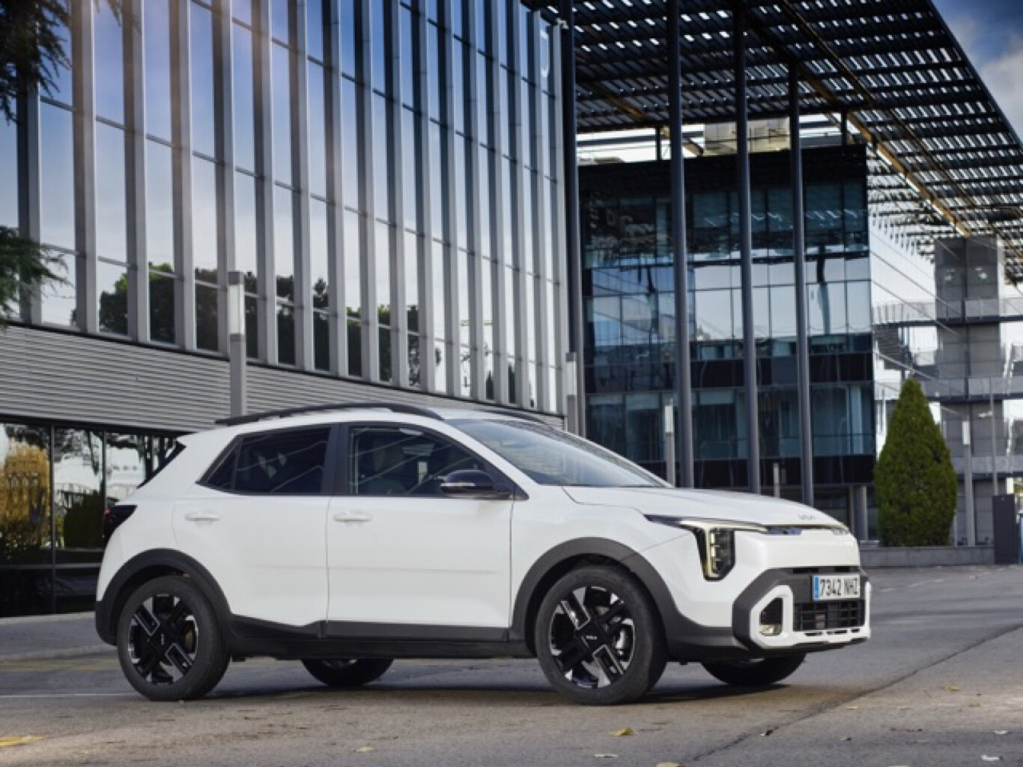 Kia Stonic 2025 blanc devant un bâtiment moderne