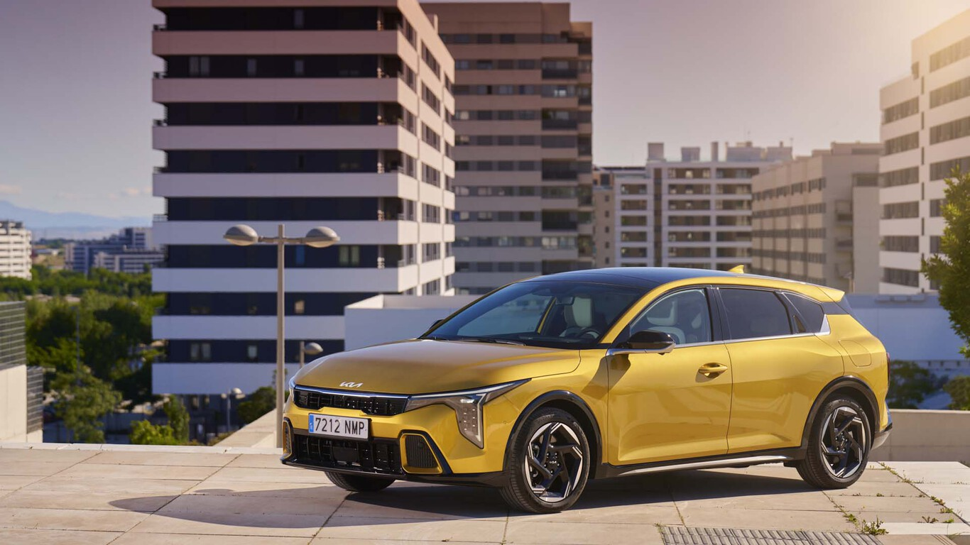 Kia K4 jaune stationnée devant des immeubles