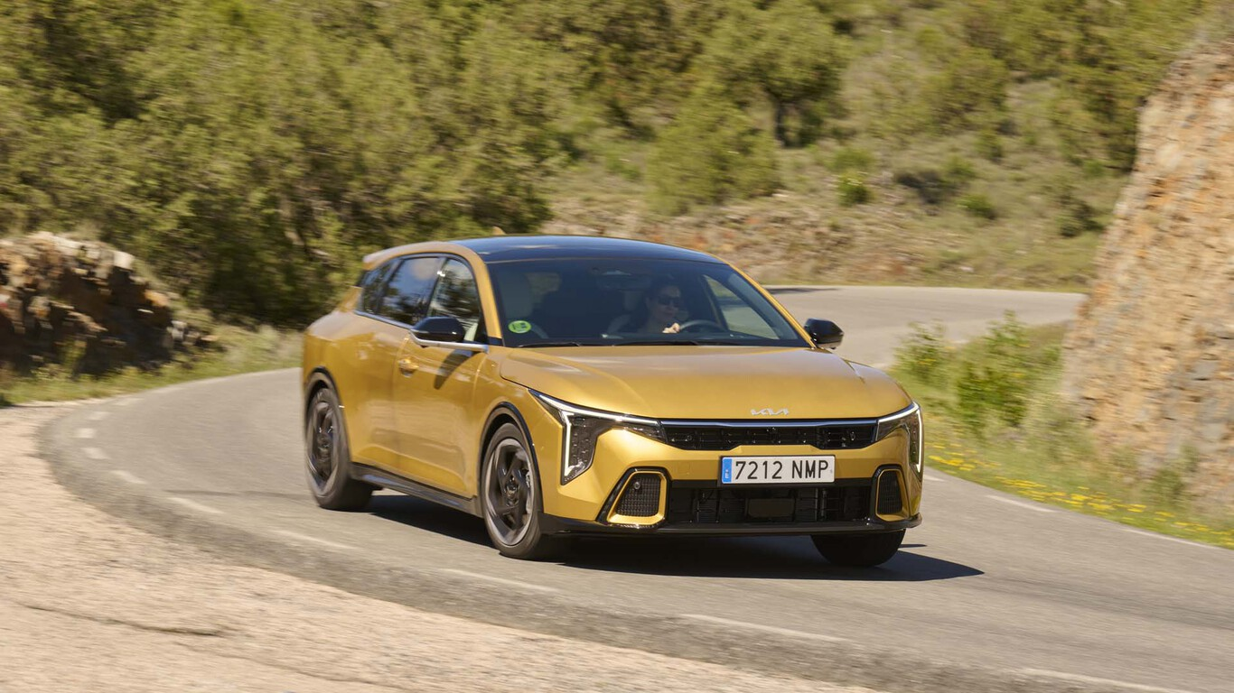 Kia K4 jaune en conduite sur route sinueuse