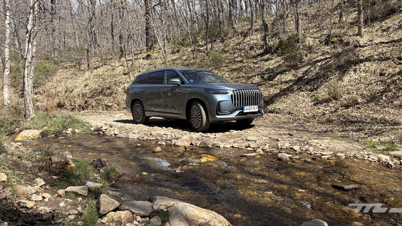 Jaecoo 8 SHS gris traversant un gué en forêt