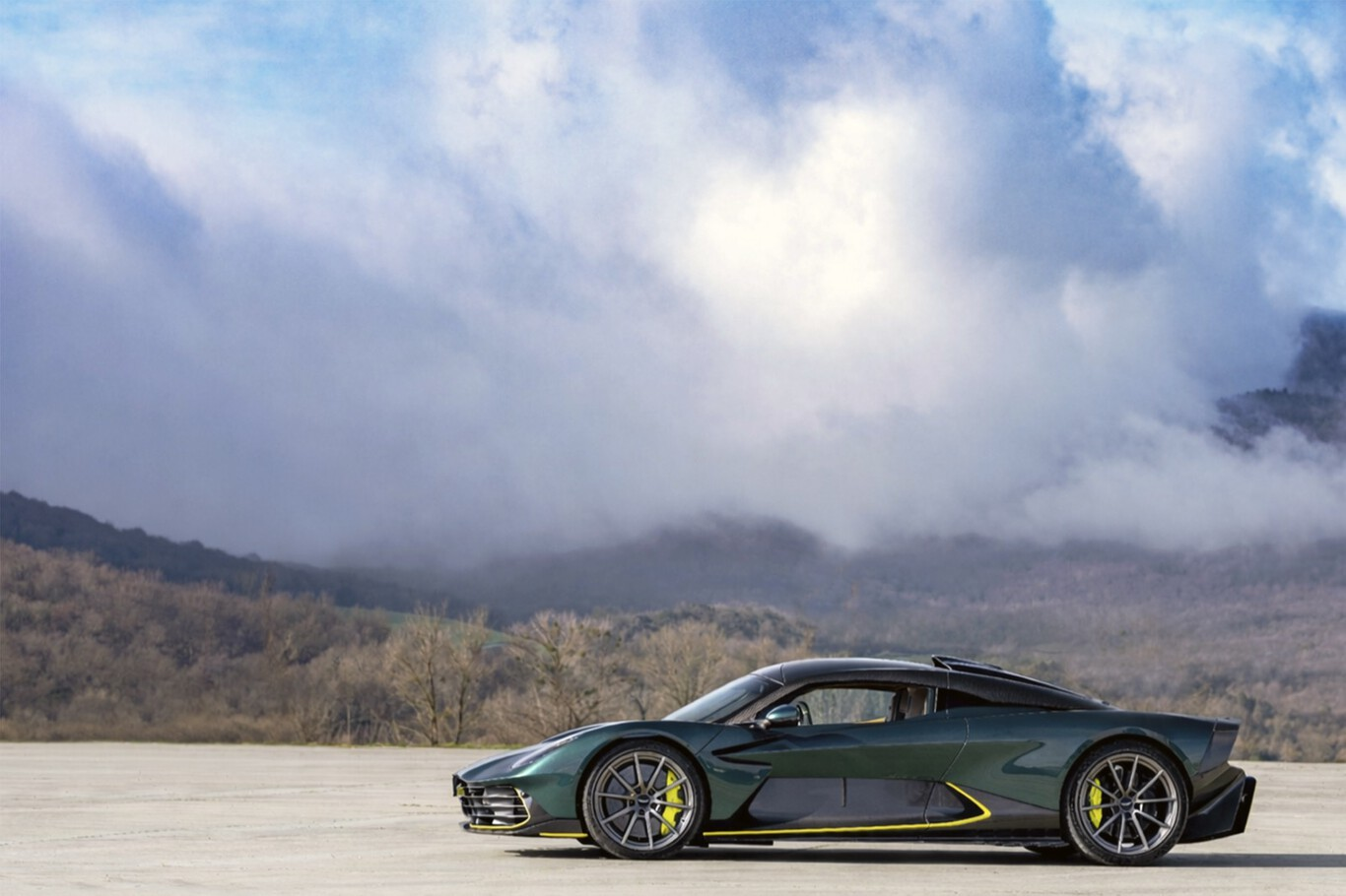 Aston Martin Valhalla de profil devant un ciel nuageux