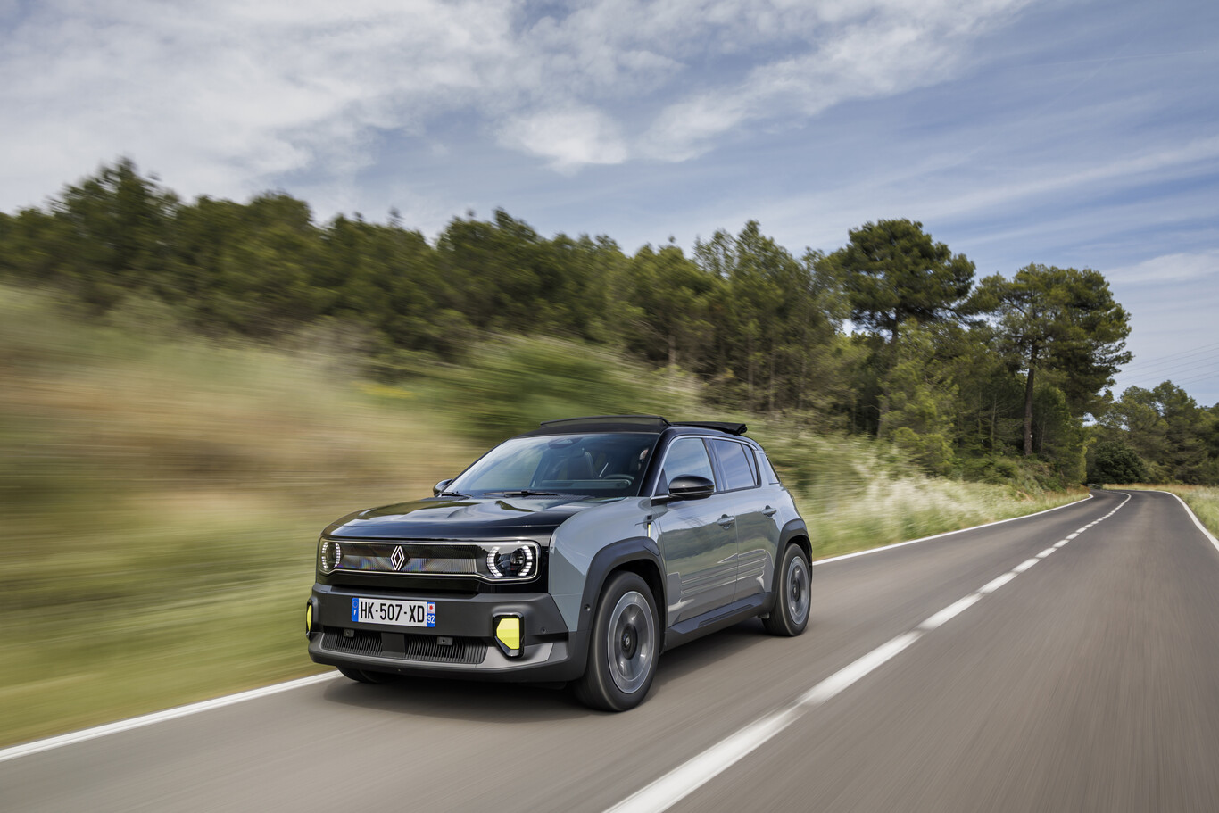 Renault 4 E-Tech Plein Sud grise roulant sur une route de campagne