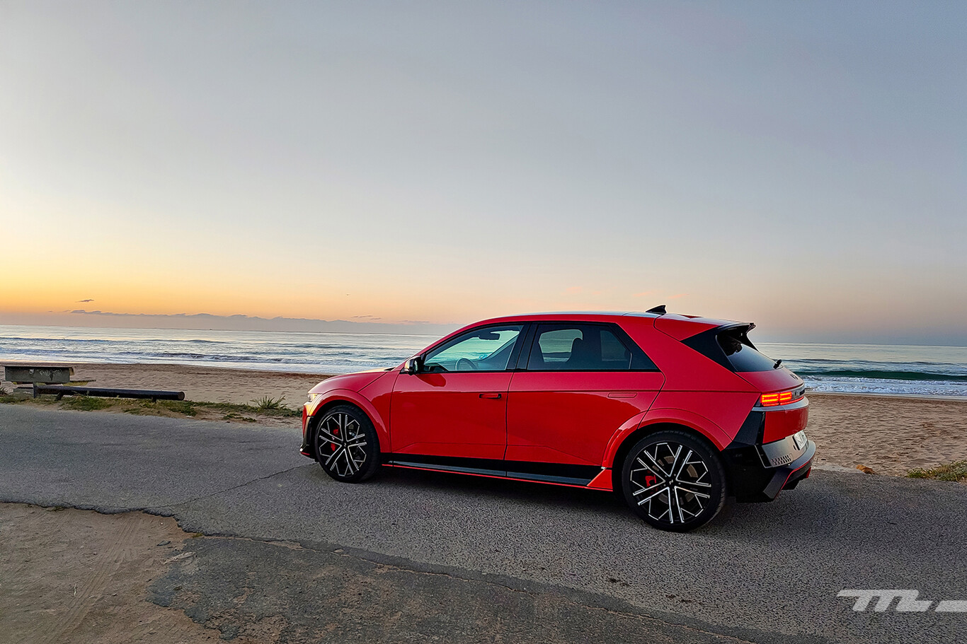 Hyundai Ioniq 5 N rouge vue de profil face à l’océan au coucher du soleil
